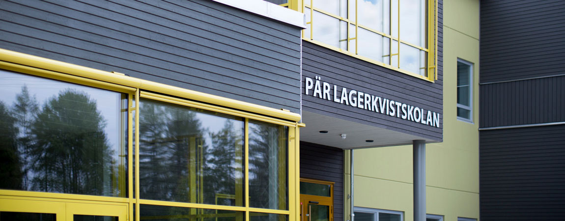 En svart byggnad med gula detaljer. På fasaden står det Per Lagerkvistskolan i vita bokstäver