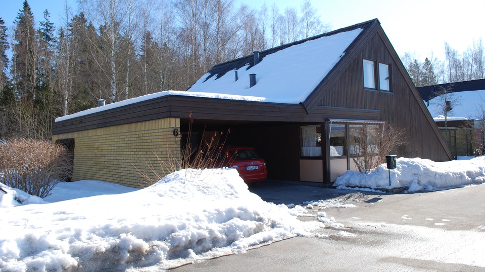Den smala träpanelen är karakteristisk, liksom den gula tegelfasaden på carporten.