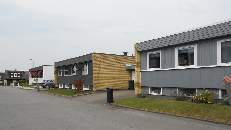 En asfalterad väg med gråa hus med gavel i tegel